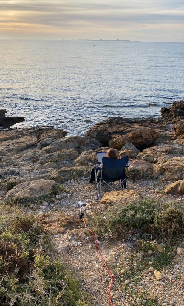 Dr. Martina Weiss beim Lektorieren eines Textes am Meer in Spanien.